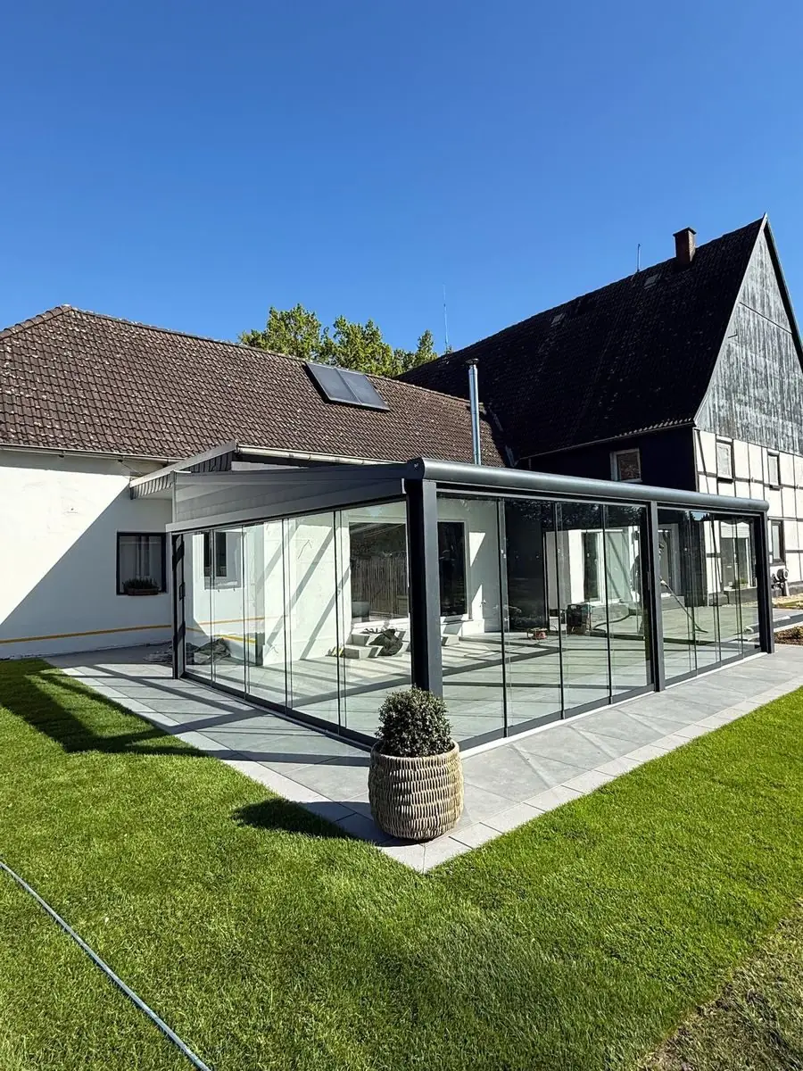 Fertiger Sommergarten aus Glas mit Feinsteinzeug-Terrasse und Rollrasen